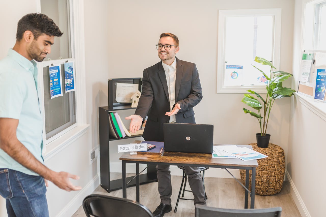 Home A professional business interaction in a modern office with a mortgage broker and client.